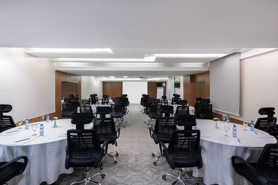 Cabaret set-up with black mesh chairs facing the projector screen in Meeting Room B at Warwick Hotel Jeddah