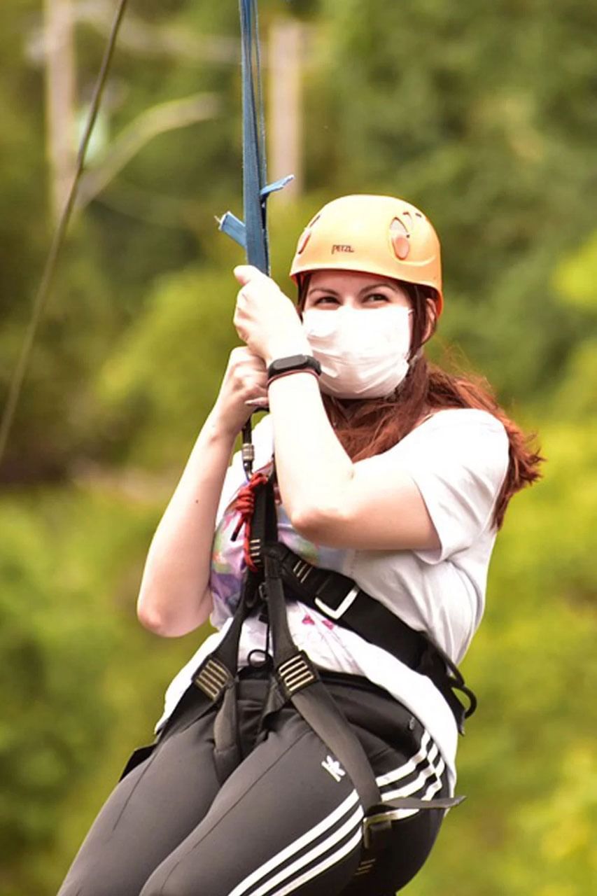 Person in a helmet and harness holding onto a zip line near The Terraces Resort & Spa