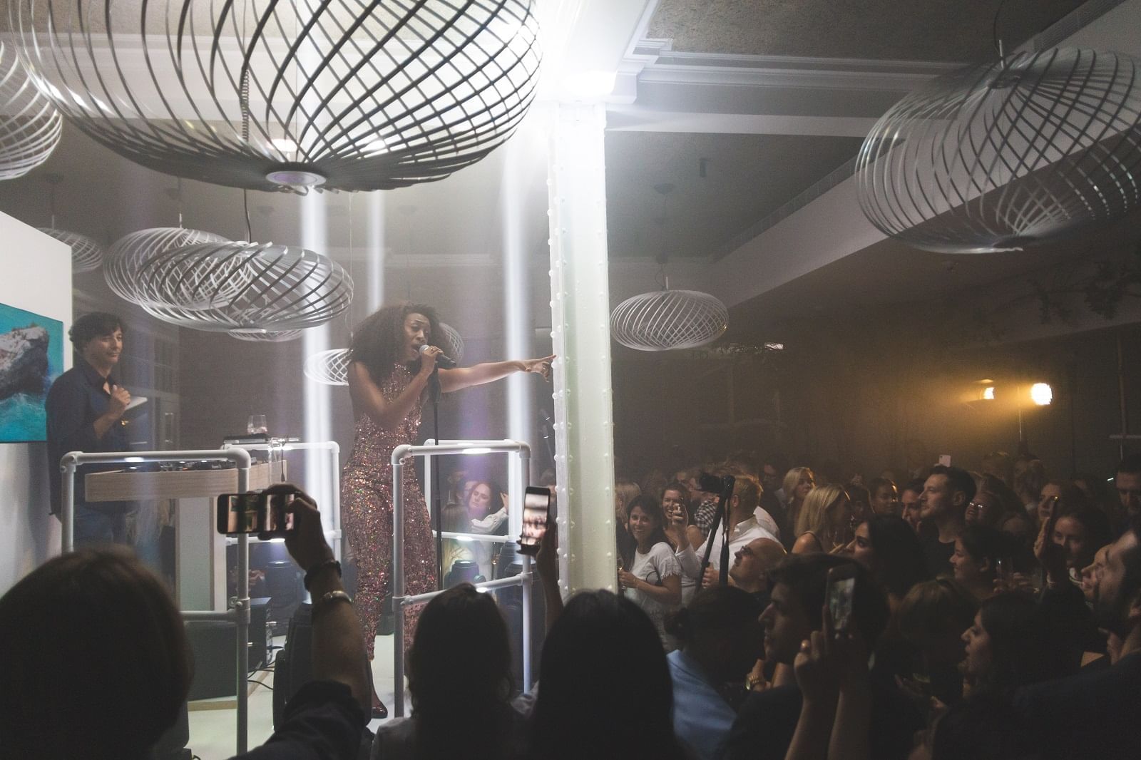 Performer in a sequined dress captivates a lively crowd at The Kitchens