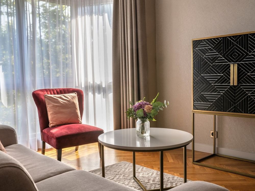 Living area with side cupboard and plush seating in the Premium Suite at Warwick Reine Astrid - Lyon