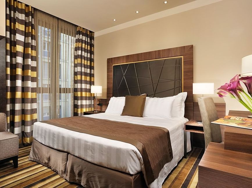 Bed & furniture in Classic King Room at Uptown Palace