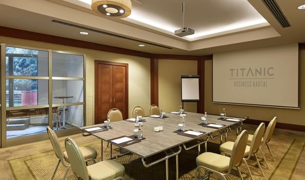 Titanic Business Kartal'daki Borneo 3 toplantı salonunda, etrafı konforlu sandalyelerle çevrili yönetim kurulu masası