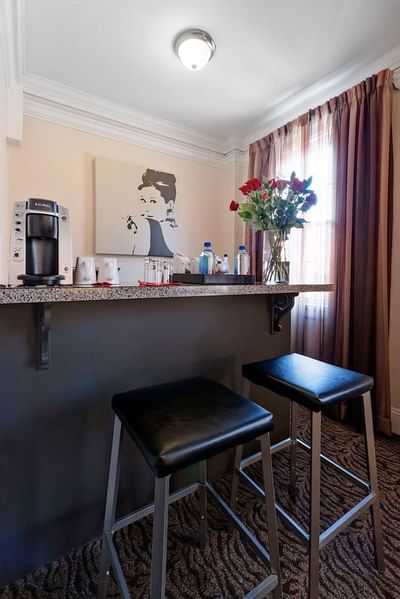 Two stools at a bar area in a hotel room at Artmore Hotel