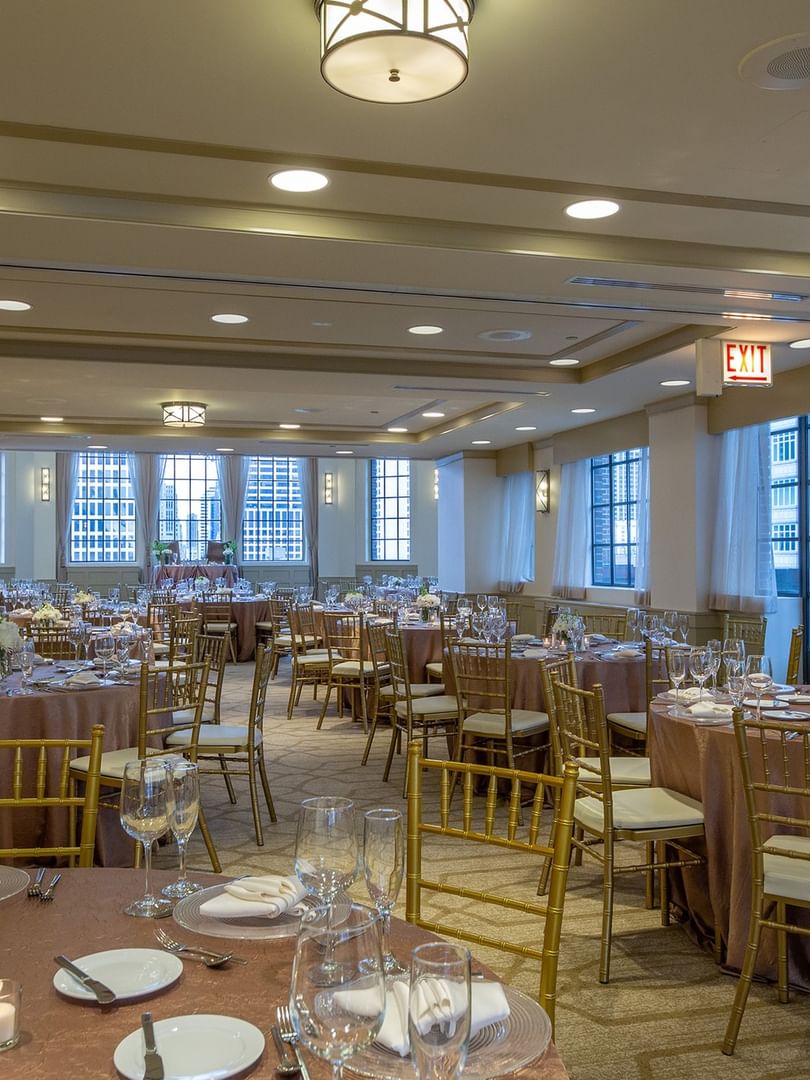 Elegantly set banquet tables near the window in Tip Top Tap Ballroom at Warwick Allerton Chicago