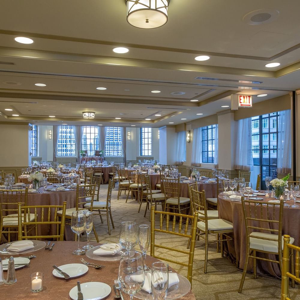 Elegantly set banquet tables near the window in Tip Top Tap Ballroom at Warwick Allerton Chicago