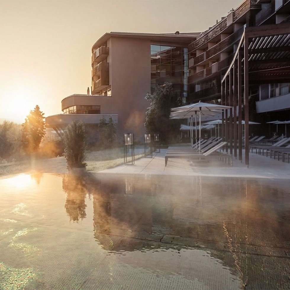 Resort Falkensteiner Balance Stegersbach con piscina e ombrelloni all'alba