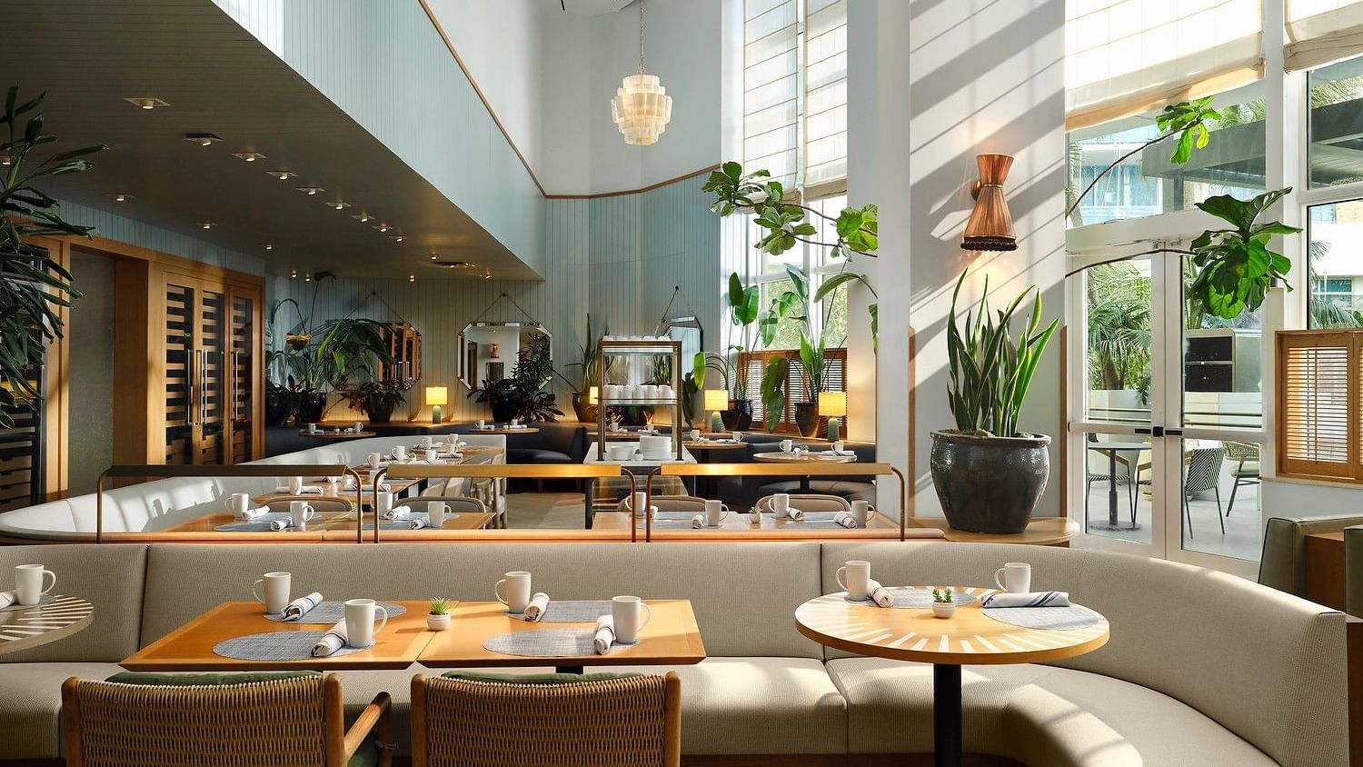 Bright Mediterranean-inspired dining room with sunlit seating.