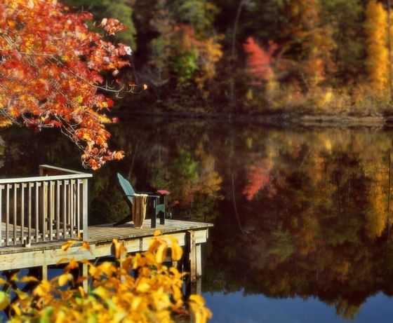 Wooden dock with a chair and towel near a colorful lake at The Clifton