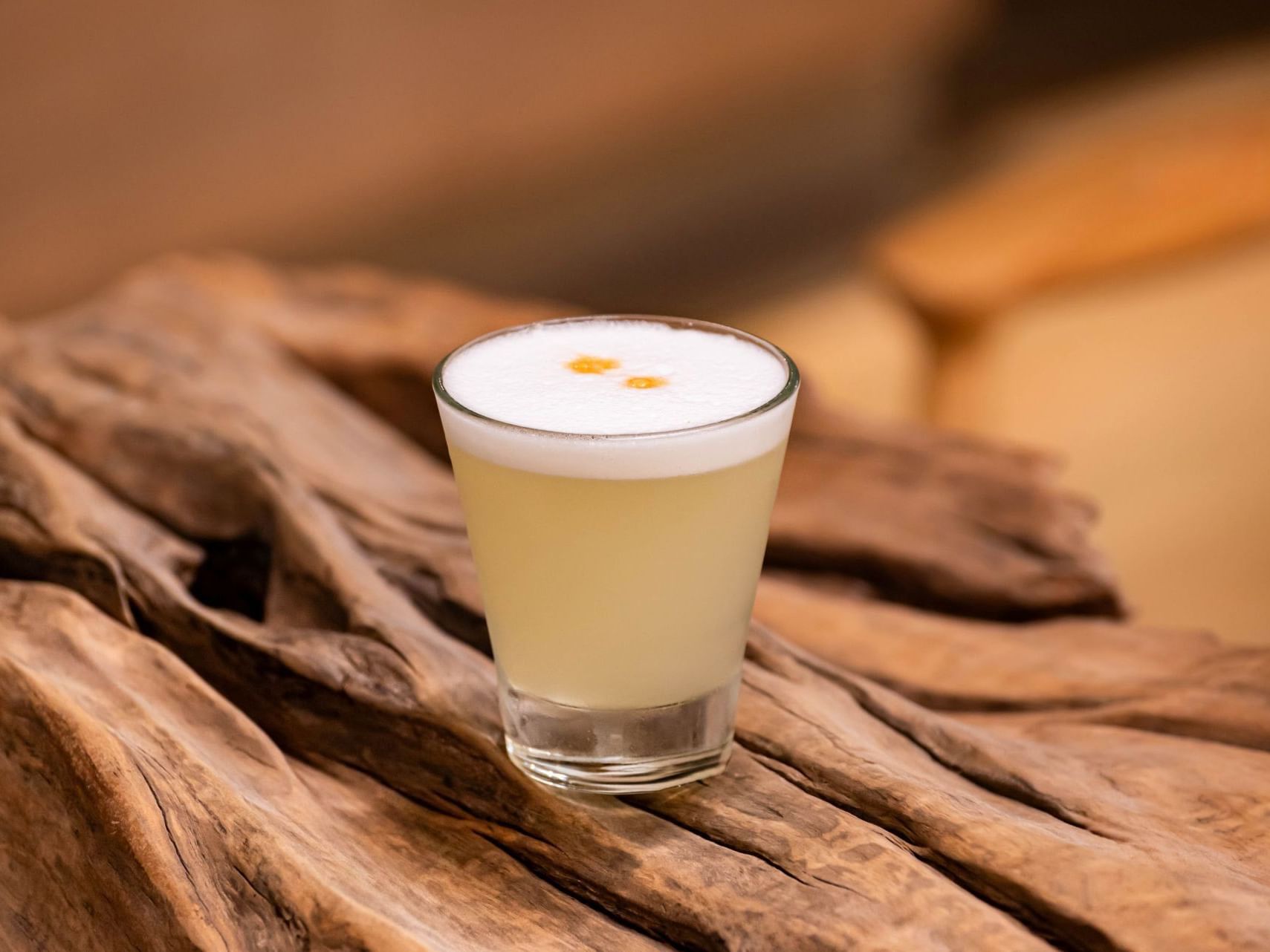 Un vaso con una bebida espumosa sobre una superficie de madera.