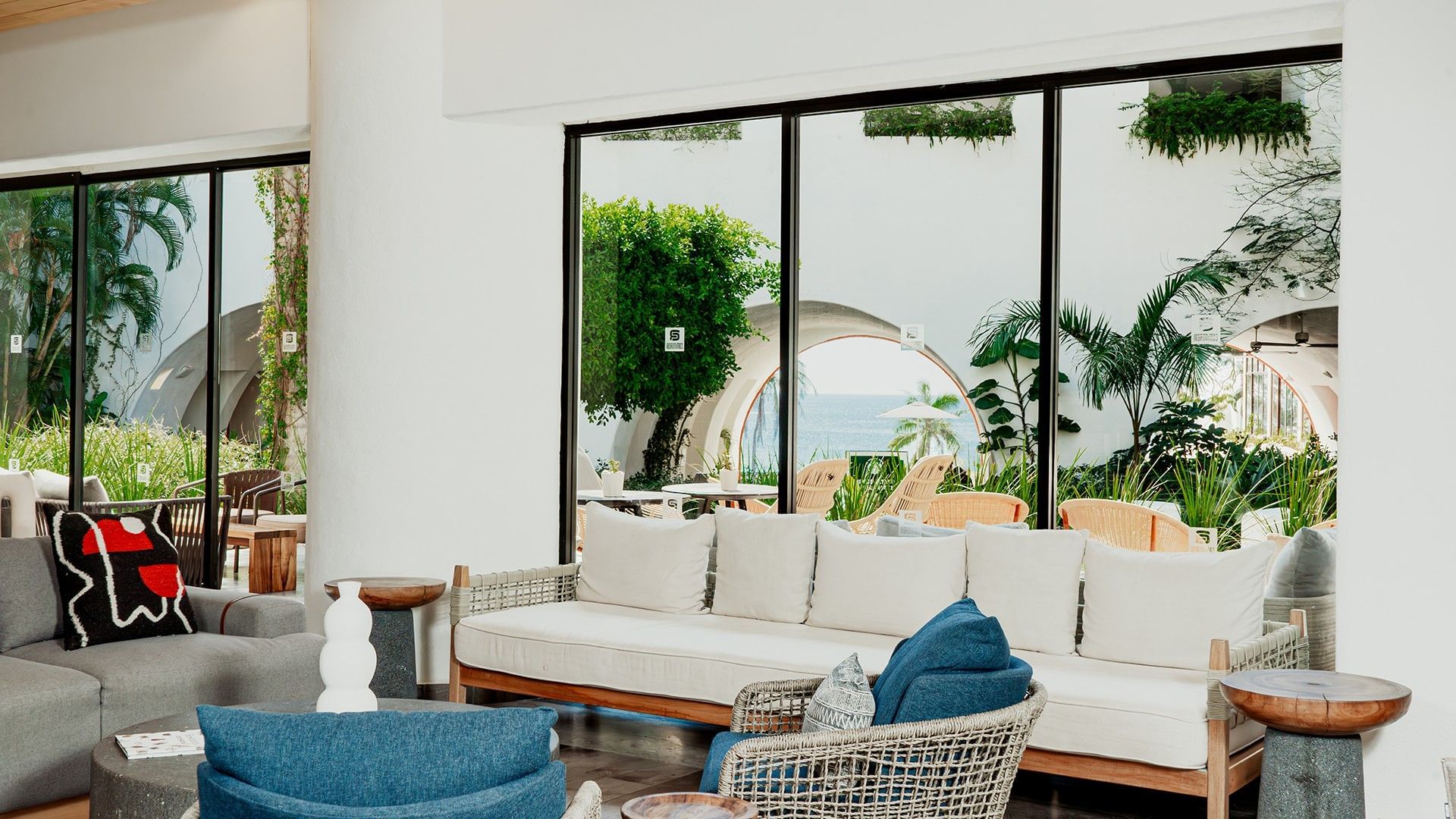 Modern lounge with plush sofas and a distant ocean view in Library Café & Deli at Camino Real Zaashila Huatulco