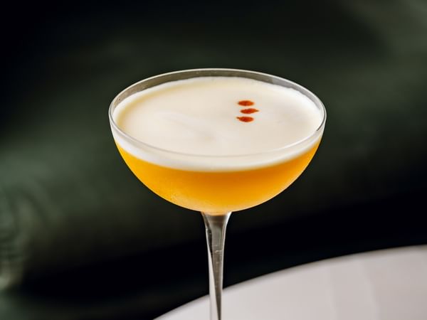Cocktail in a martini glass with three red dots at The Capital Hotel, Apartments & Townhouse.