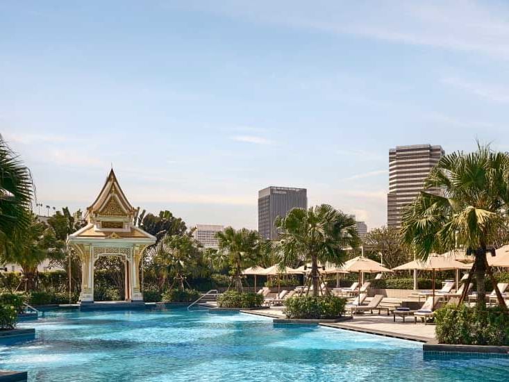 Outdoor pool with sun loungers at Chatrium Grand Bangkok