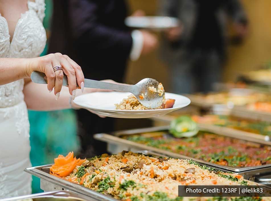 A woman was filling her plate with delicious food - Lexis Suites Penang