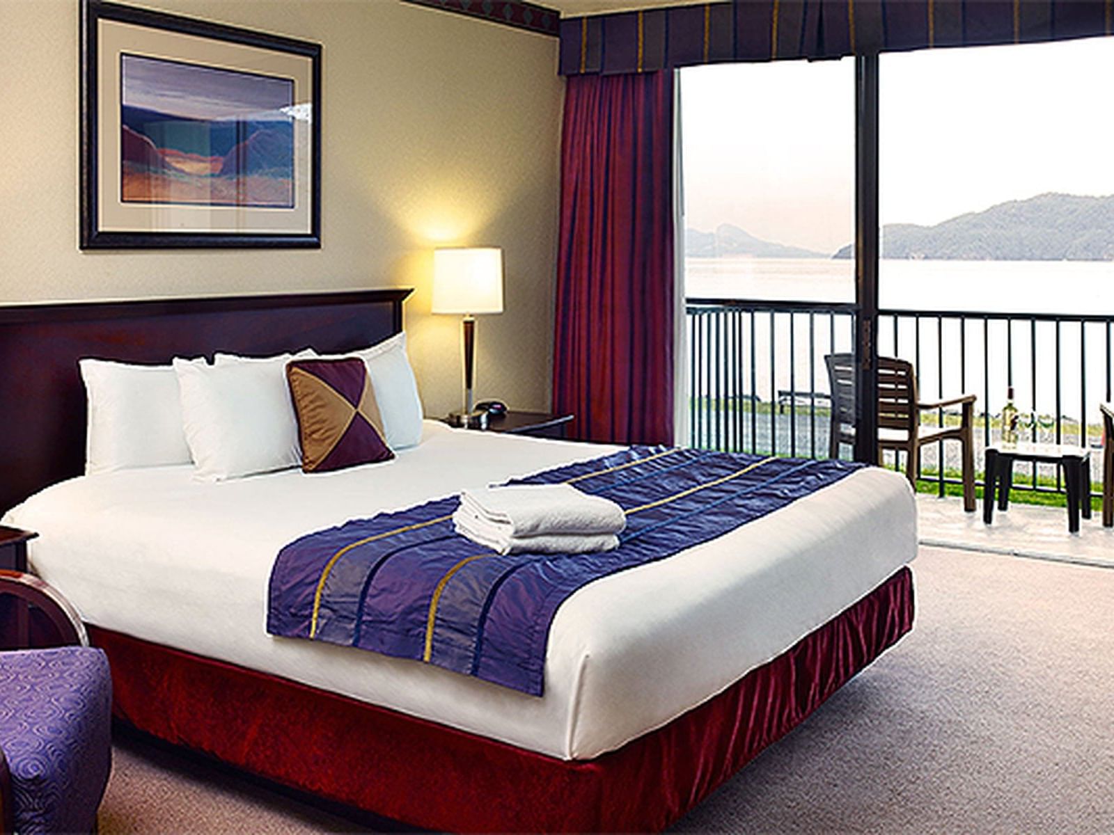 bed in hotel room with balcony overlooking ocean