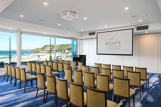 Pacific West or Private Dining Room at Noah's On the Beach, featuring rows of chairs, a projector screen, and ocean views