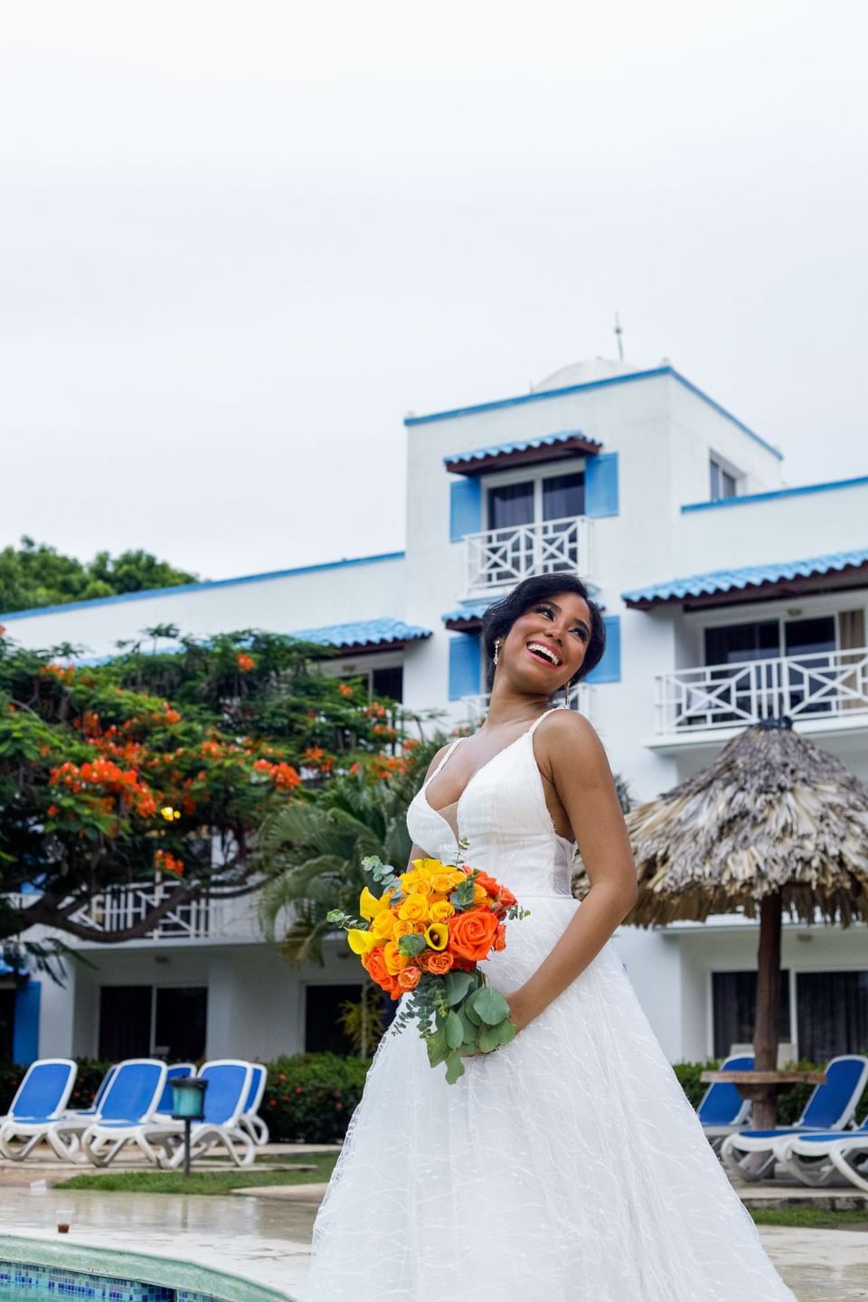 Bride posing outdoors holding a rose flower bouquet at Playa Blanca Beach Resort