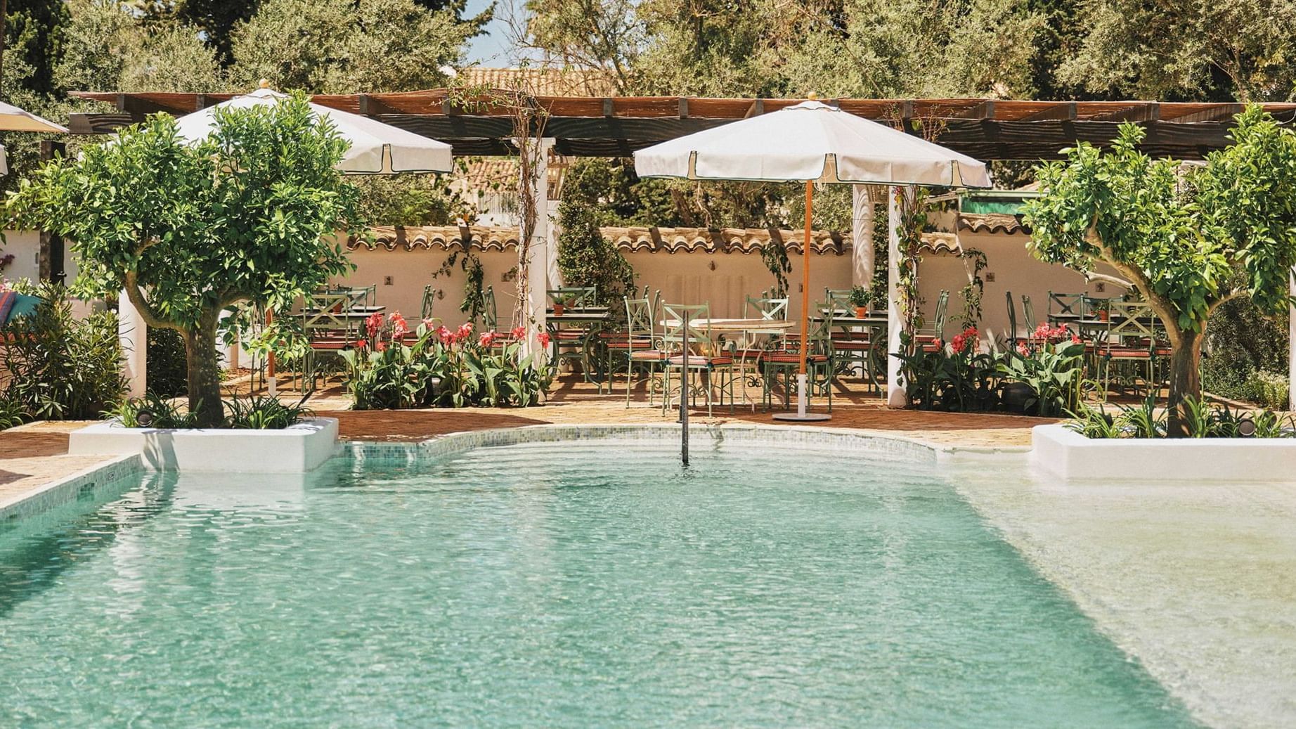 Outdoor pool and dining area at El Olivar by Chef Andrés, Marbella Club in Marbella.