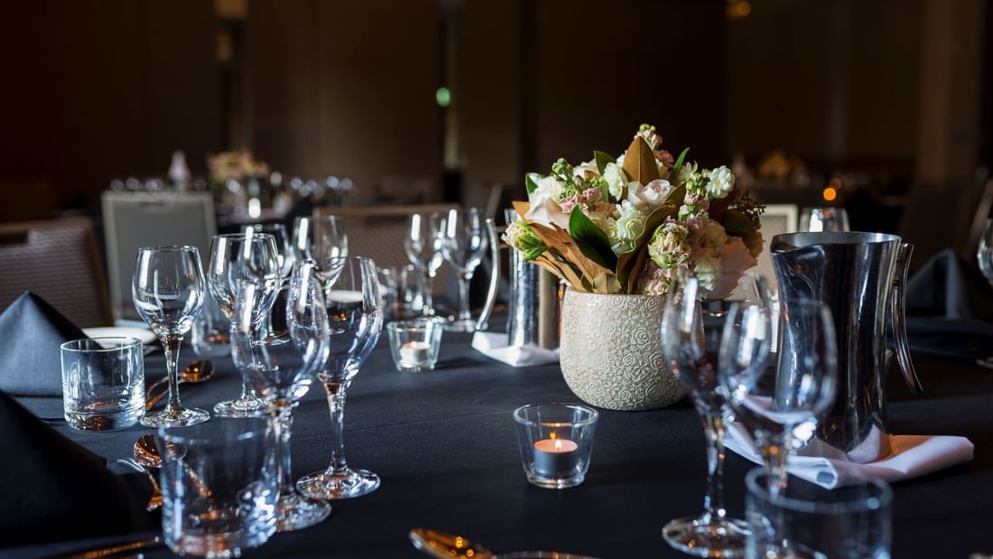 Table arrangement with glasses, flower display and lit candles for an Event at Pullman Sydney Olympic Park