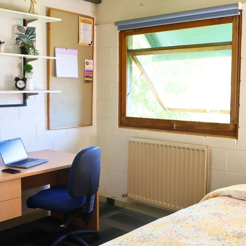 Cozy room with desk, laptop, radiator, and bed at La Trobe University - Units.