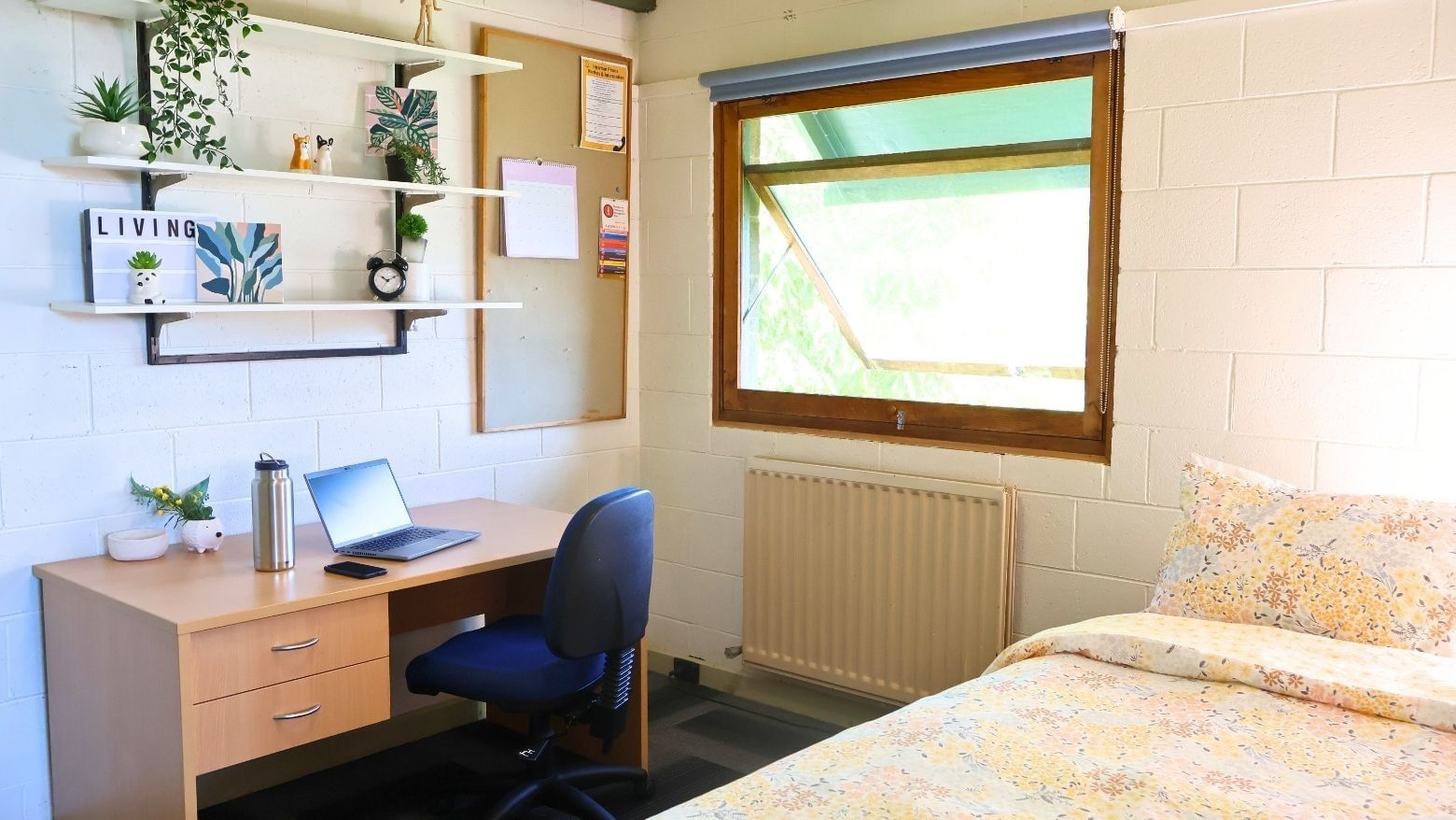Cozy room with desk, laptop, radiator, and bed at La Trobe University - Units.