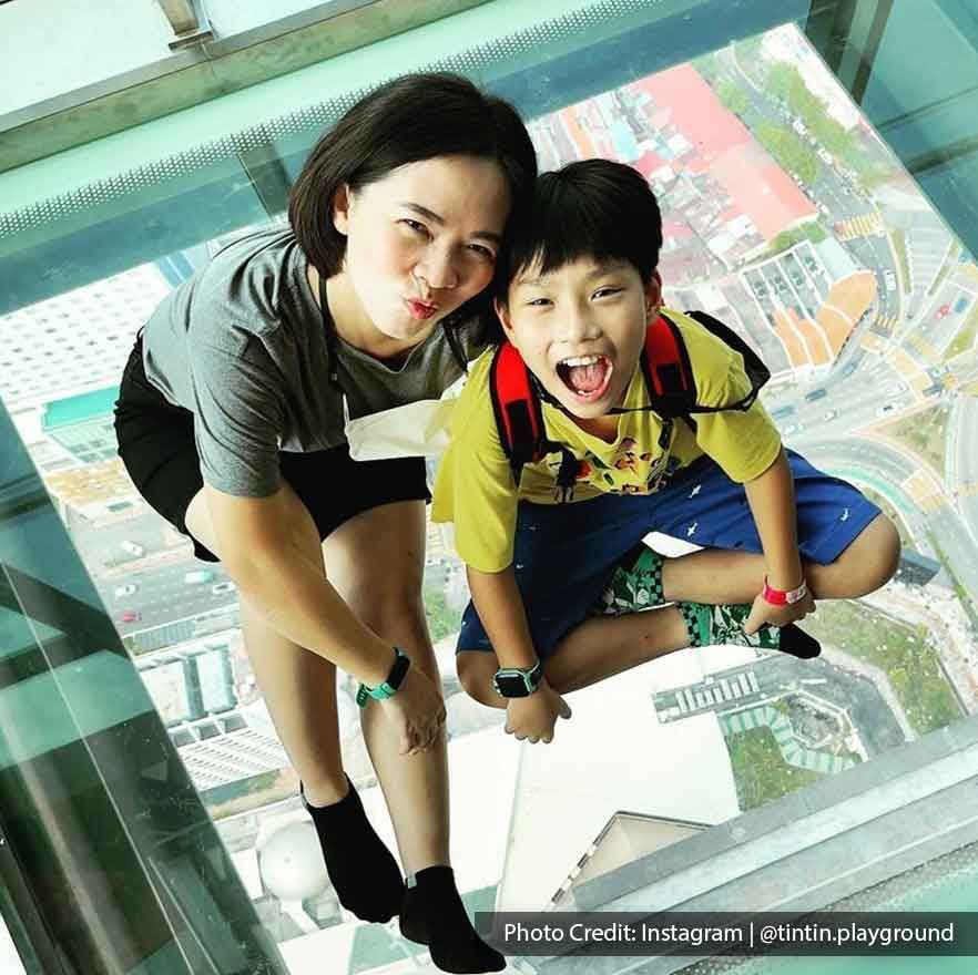 A woman was taking a picture with her kid at The TOP Penang Rainbow Skywalk- Lexis Suites Penang
