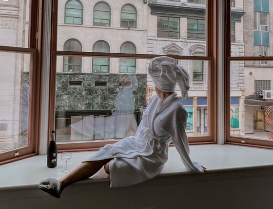 A lady in a bathrobe gazing out the window at ReStays Ottawa