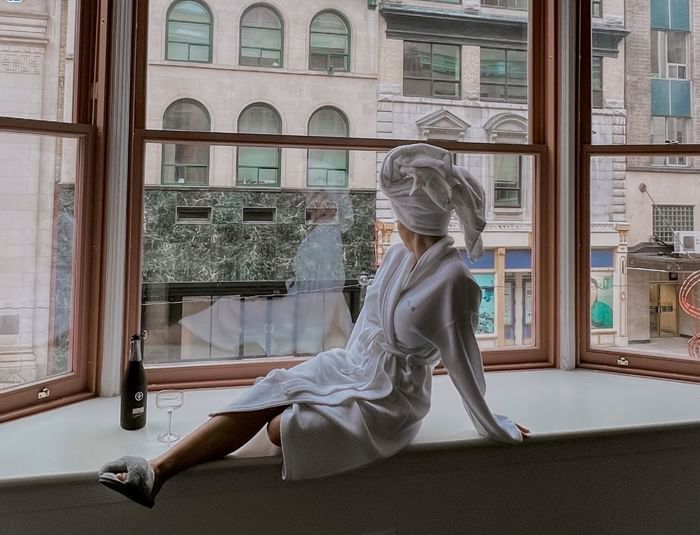 A lady in a bathrobe gazing out the window at ReStays Ottawa