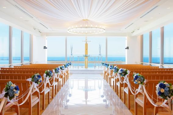 Wedding chapel interior with rows of pews & ocean view at Grand Park Otaru