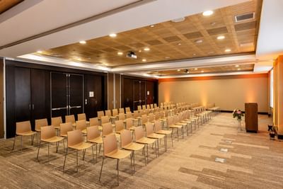 Large conference hall set up with rows of chairs facing a presentation screen in Libertad at Veranda Hotel