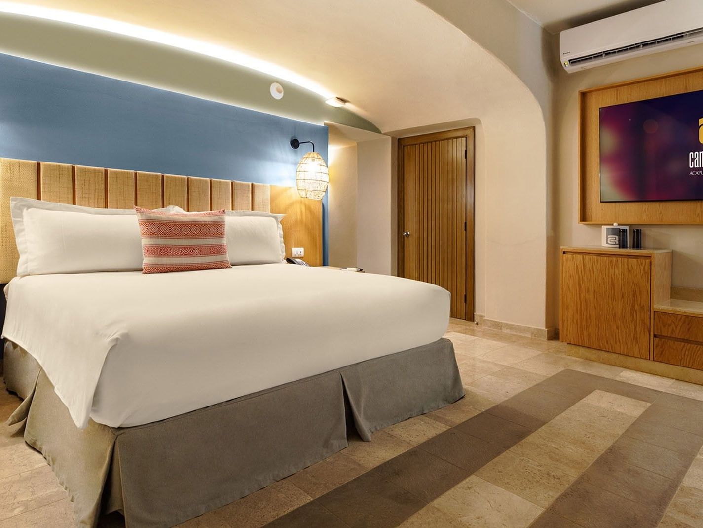 Ocean View King Deluxe Superior Room with blue wall, flat screen TV, & wooden media console at Camino Real Acapulco Diamante