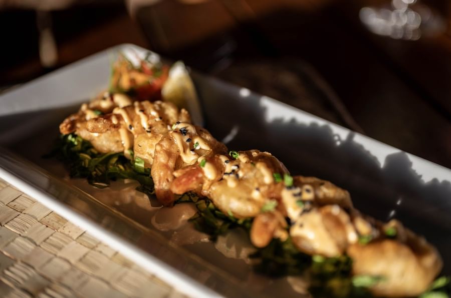 Platter of fried shrimp with sauce and greens by a lemon wedge in Wicked Walu at Warwick Fiji Resort and Spa