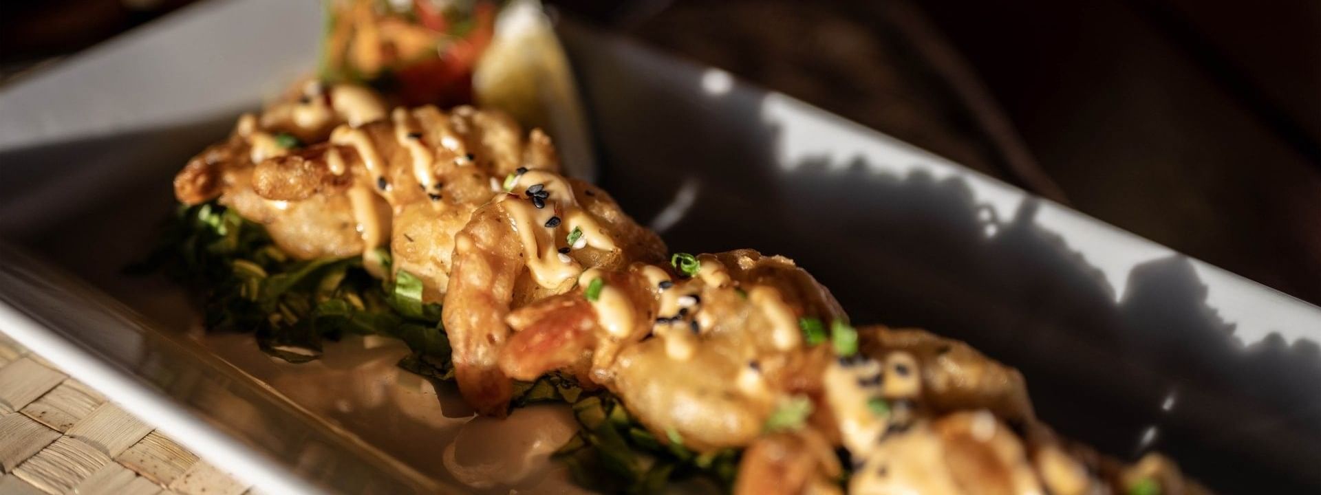 Platter of fried shrimp with sauce and greens by a lemon wedge in Wicked Walu at Warwick Fiji Resort and Spa