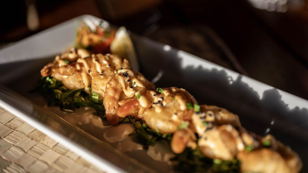 Platter of fried shrimp with sauce and greens by a lemon wedge in Wicked Walu at Warwick Fiji Resort and Spa