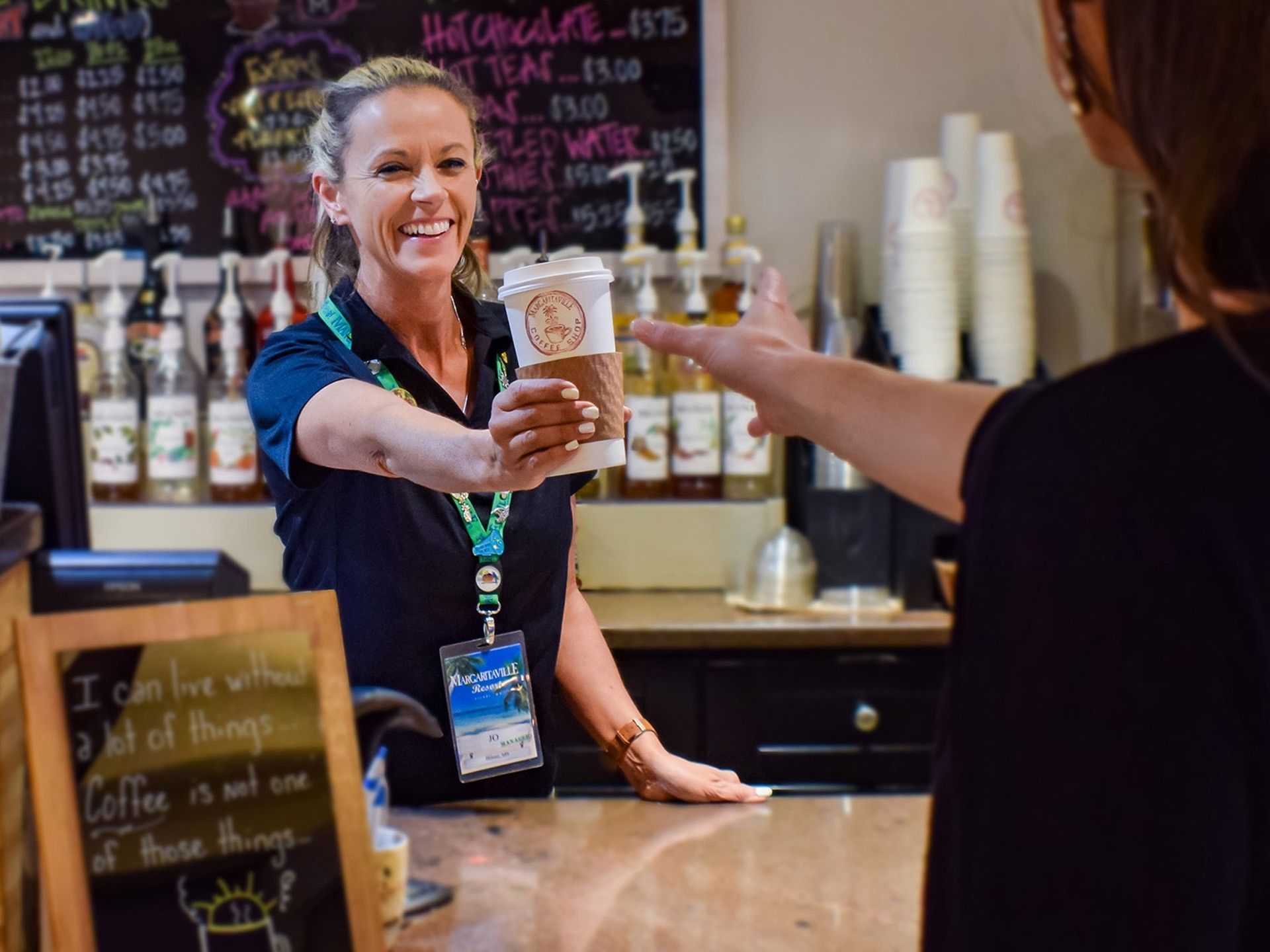 Friendly barista serving a hot cup of coffee in Coffee Shop at Margaritaville Resort Biloxi