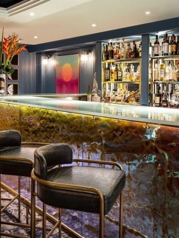 Capital Bar featuring dark leather stools placed by a glowing counter at The Capital Hotel, Apartments and Townhouse