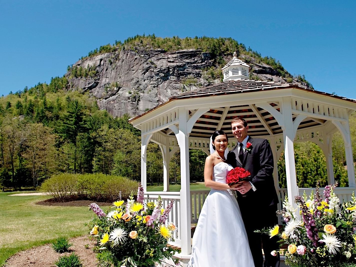 Wedded couple posing by a Gazebo at White Mountain Hotel 