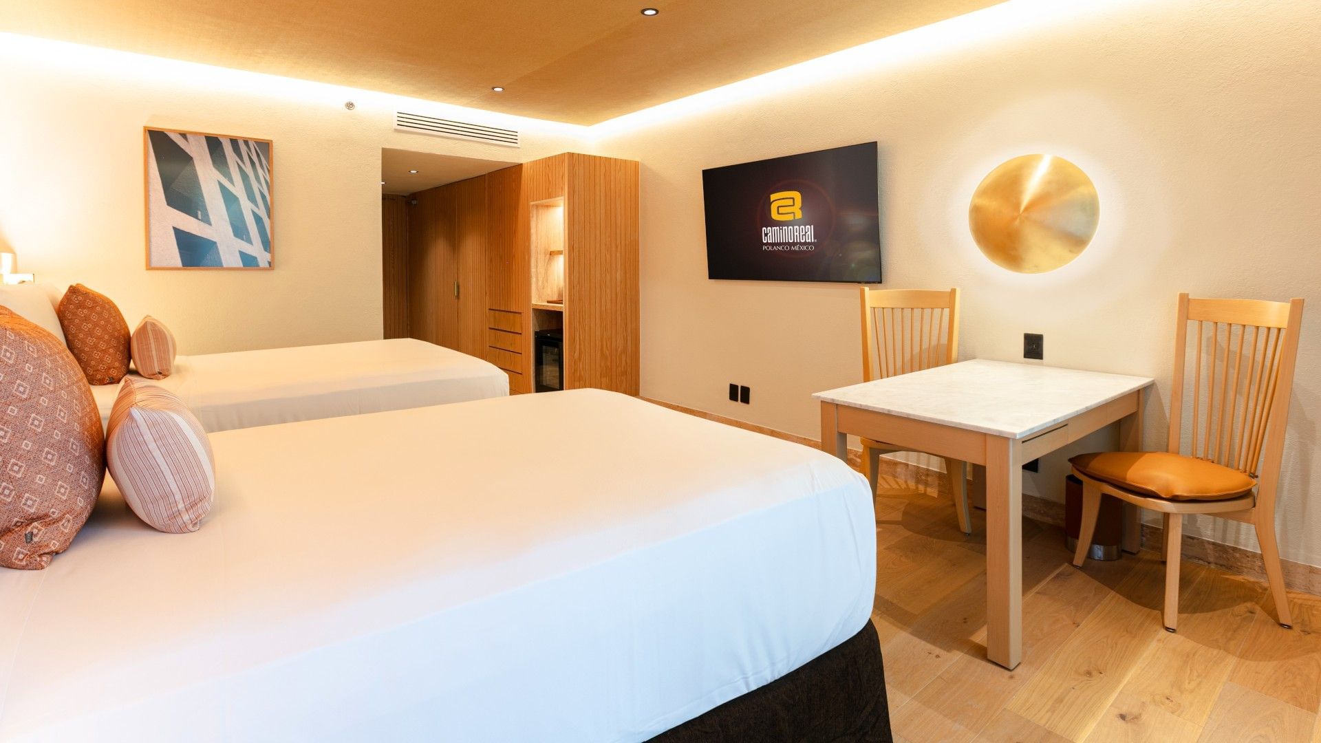 2 Double Deluxe Plus room with light wood furniture, a marble table, and ambient lighting at Camino Real Polanco Mexico