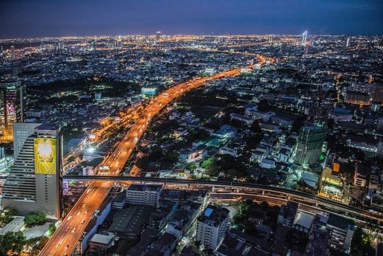 View from Paradox Bangkok Hotel on Sukhumvit Road with lit highway by city buildings under a dark starry night