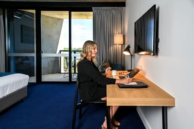 Lady working by the Suite work desk, Nesuto Curtin Perth Hotel