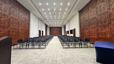 Spacious event hall set up with rows of chairs facing a stage ideal for large conferences at Habitel Hotel Select