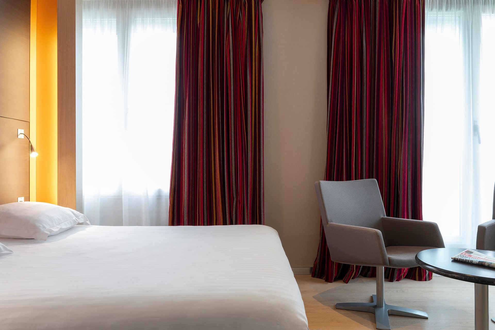 Lit queen et fauteuil dans une chambre supérieure à Oceania Brest Centre