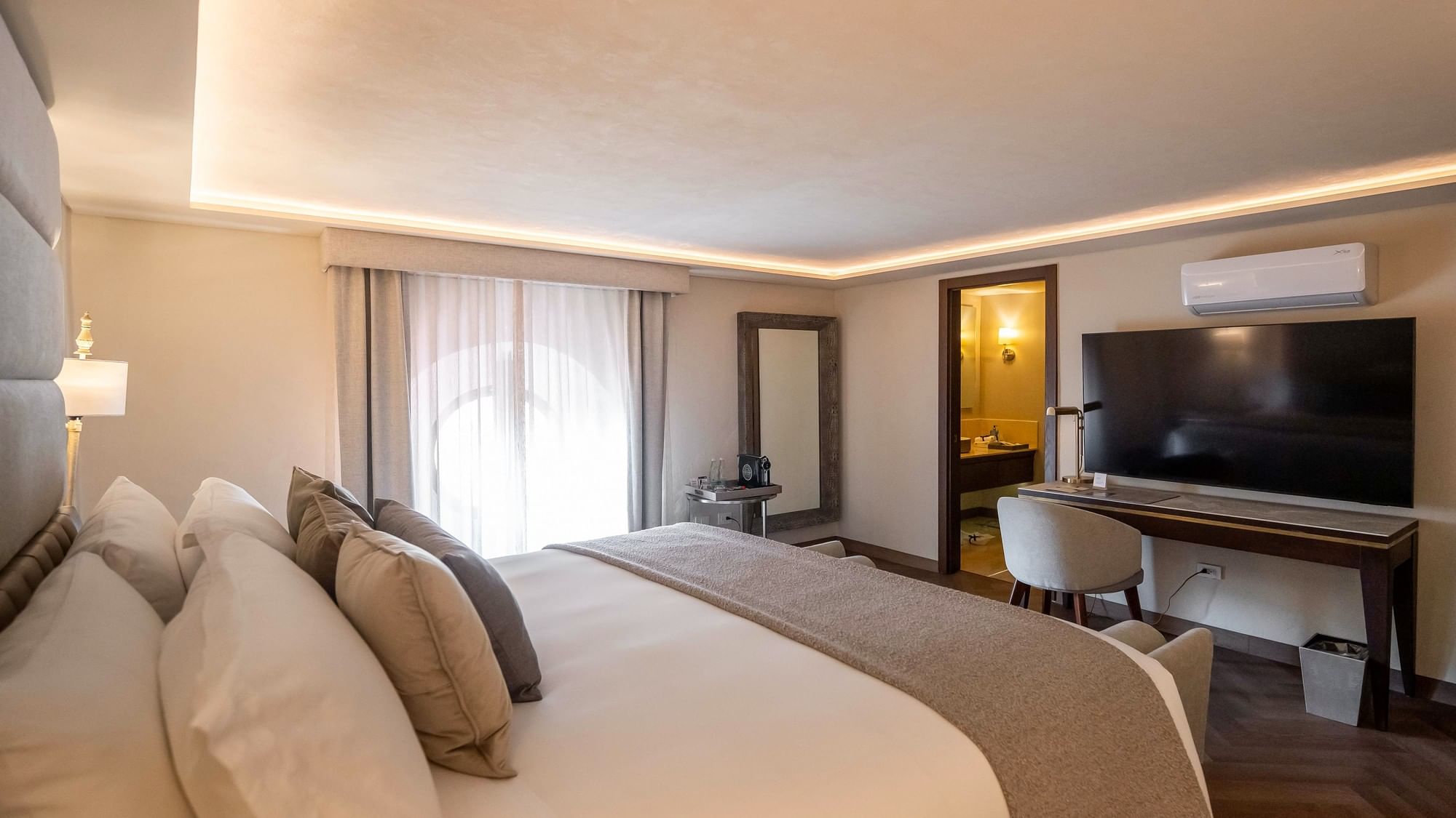 Habitación de lujo con cama King, televisor, escritorio y baño en Quinta Real Puebla, Heroica Puebla de Zaragoza