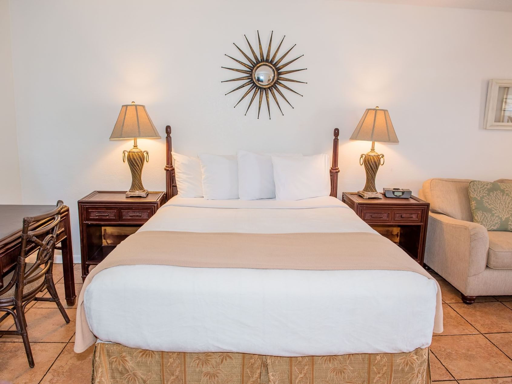 Queen bed with nightstands and seating area in White Sands Suite at Ocean Lodge Boca Raton