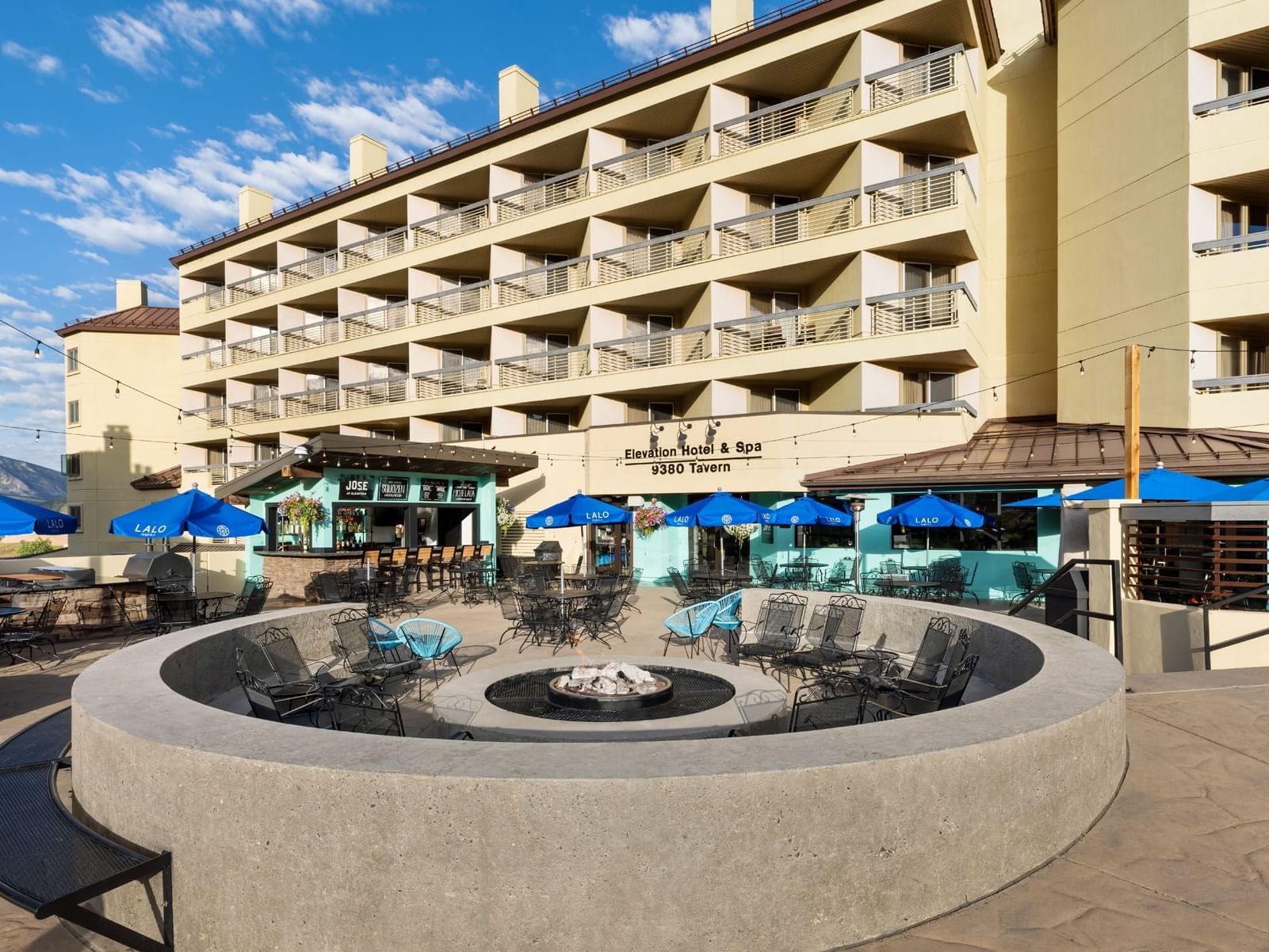 Elevation Hotel Resort & Spa building with outdoor patio featuring a fire pit and seatings.