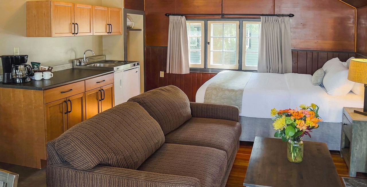 Interior of cabin with dining area, bed, sitting area, and kitchen