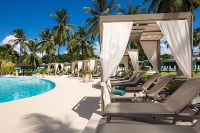 Luxury poolside cabanas with loungers on a sunny day at All Seasons Resort Europa