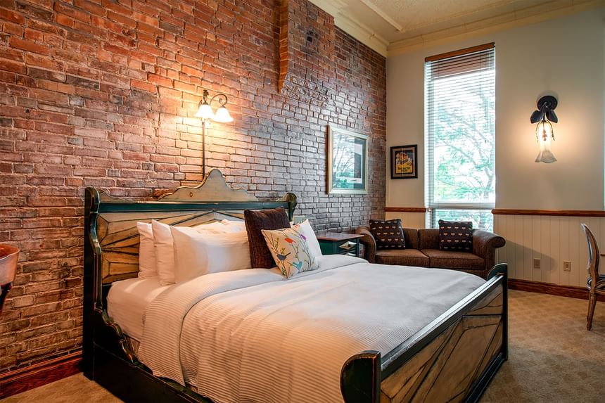 king bed in home suite home, love seat with lots of exposed bric