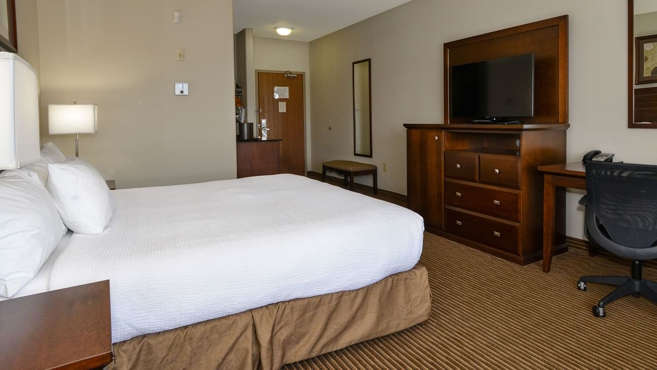 Hotel room with king bed, large TV, work desk and chair