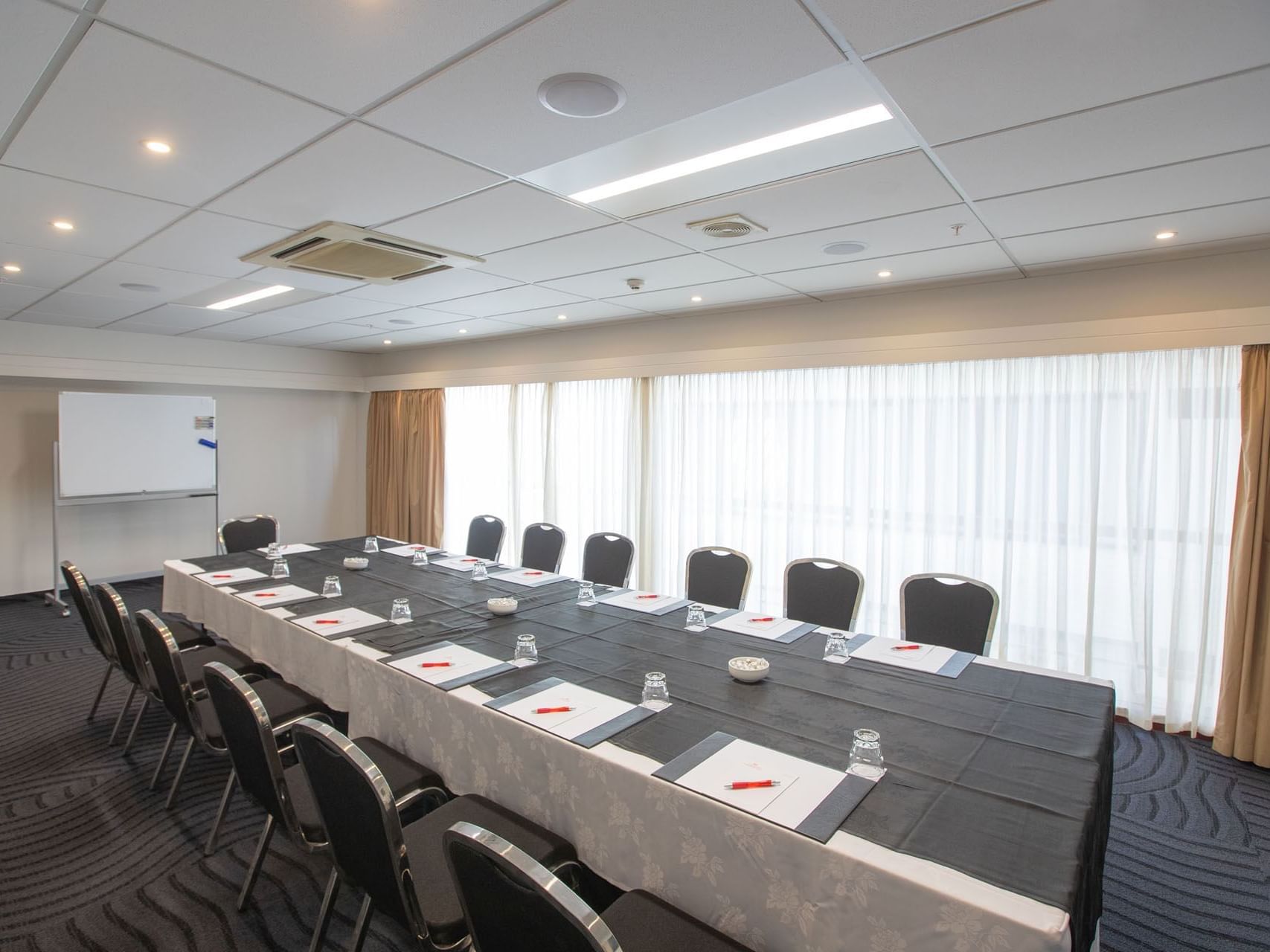 Conference table set-up in Chancellor 5 with carpeted floors at James Cook Grand Chancellor