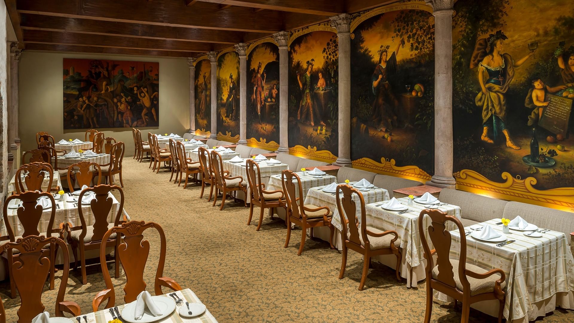 Elegant dining room with white-clothed tables, wooden chairs, and historic murals on arched walls at Quinta Real Aguascalientes